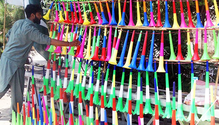 A vendor displays colourful plastic horns at Murree Road in connection with the 75th Independence alongside a road in Rawalpindi, on August 13, 2022. — Online