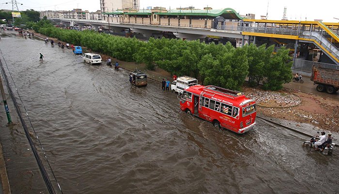 A view of vehicles passing through accumulated rain water during rain in Karachi, on August 10, 2022. — INP