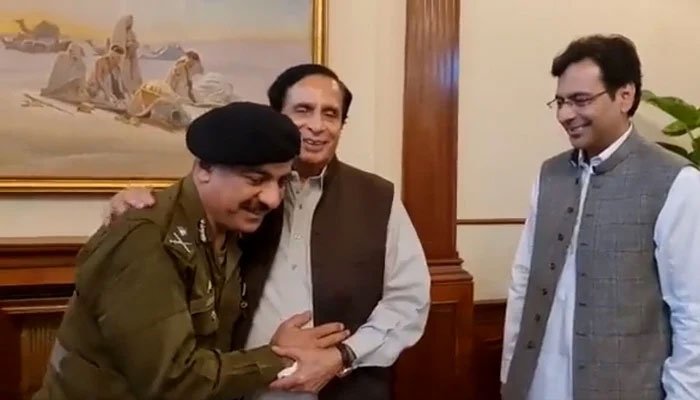 Punjab CM Pervaiz Elahi pats the back of Lahore CCPO Ghulam Dogar after he denied to follow orders from the federal government to relinquish his charge. — Screengrab