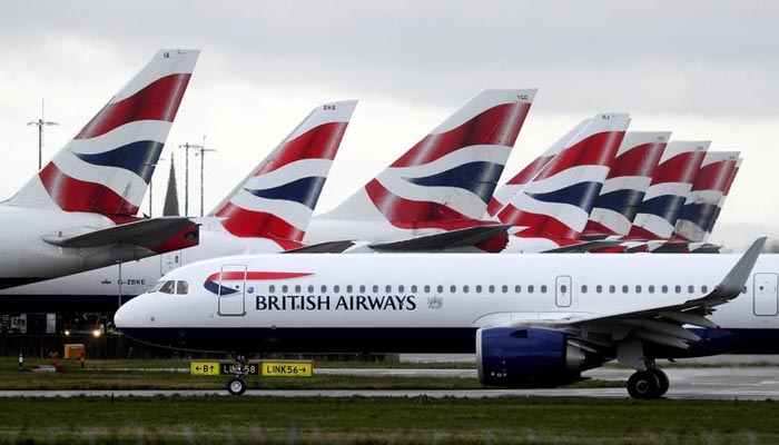 A British Airways plane taxis past tail fins of parked aircraft to the runway near Terminal 5 at Heathrow Airport in London, Britain March 14, 2020. — Reuters/File