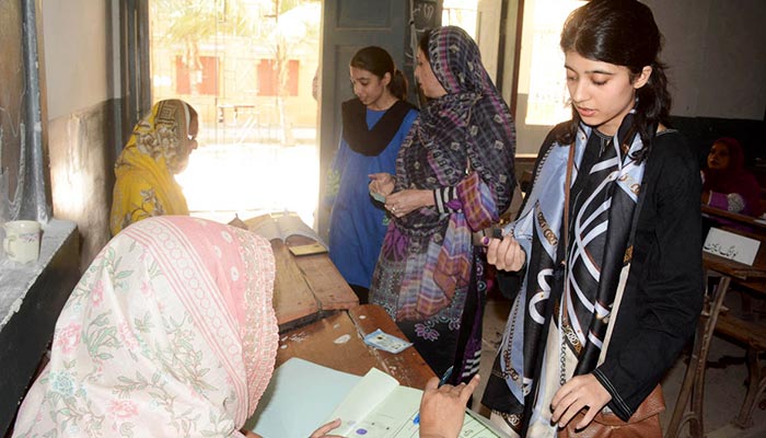 Girls standing in a queue to exercise their right to vote at a polling station for by-elections on NA- 239, on October 16, 2022. — APP