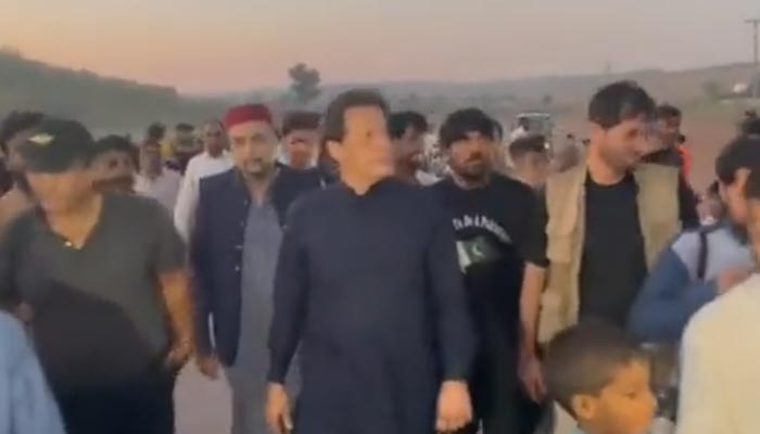 PTI chief and former prime minister Imran Khan walks towards Bani Gala after his helicopter made an emergency landing near Adiala jail on October 8, 2022. — Twitter