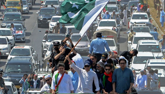 PTI Chairman Imran Khan leads a long march on a container. — AFP/File