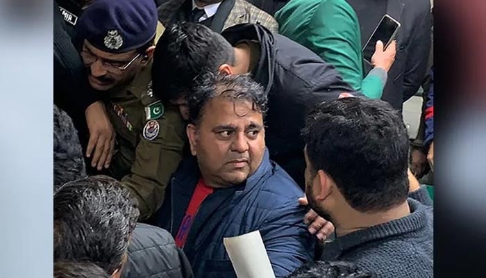 Police officials escort the arrested leader of opposition Pakistan Tehreek-e-Insaf (PTI) party, Fawad Chaudhry (C) to present him before a court in Lahore on January 25, 2023. — AFP