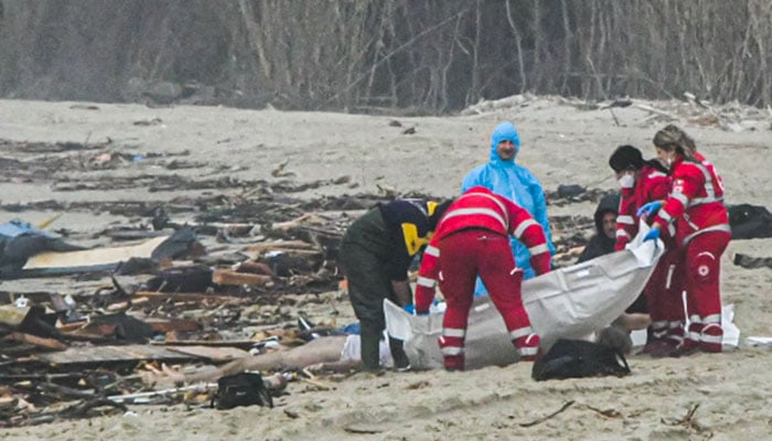 This photo obtained from Italian news agency Ansa, taken on February 26, 2023 shows rescuers handling a body bag at the site of a shipwreck in Steccato di Cutro, south of Crotone, after a migrants’ boat sank off Italy’s southern Calabria region. — AFP