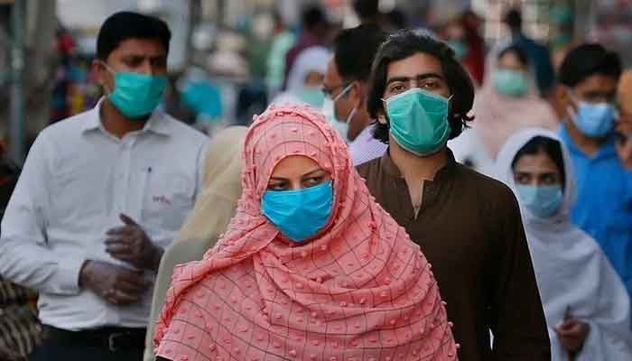 Masked people walk in a market amid the fourth wave of the coronavirus pandemic in Pakistan. Photo: AFP