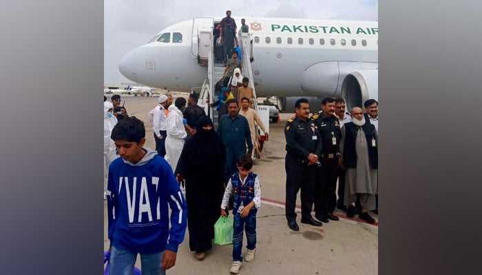 Stranded Pakistanis stepping out of aircraft after reaching Karachi. —FO