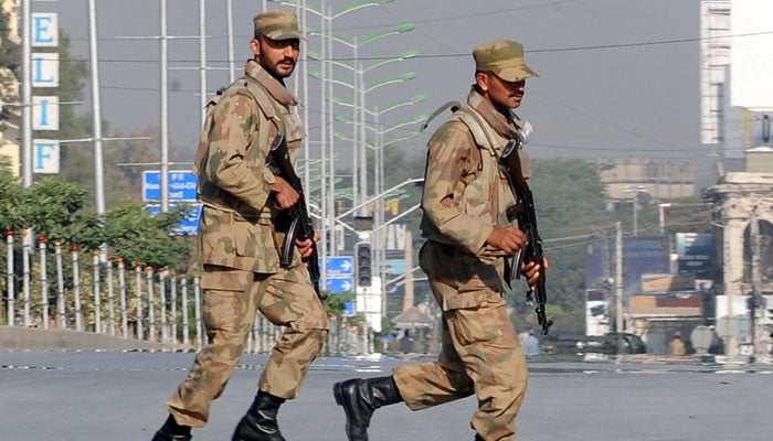 Pakistani troops take up positions at army headquarters during an encounter with militants Sunday in Rawalpindi. — AFP/File