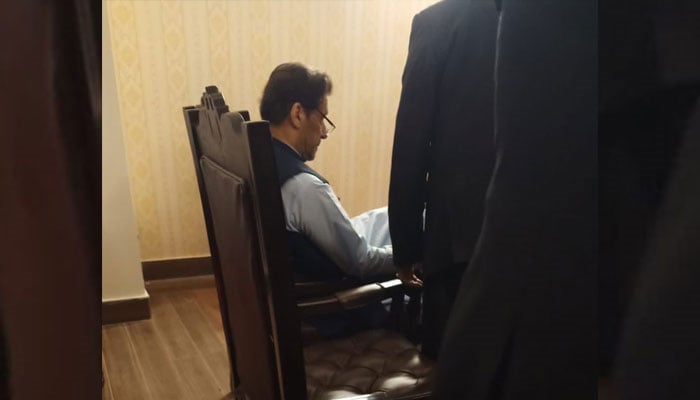 Former prime minister Imran Khan sits on a chair in the NAB courtroom on May 10, 2023. — Geo News