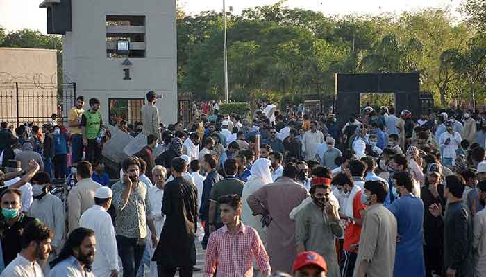 PTI activists and supporters of former prime minister Imran Khan, gather outside the main entrance of General Headquarters during a protest against the arrest of their leader, in Rawalpindi on May 9, 2023.—AFP