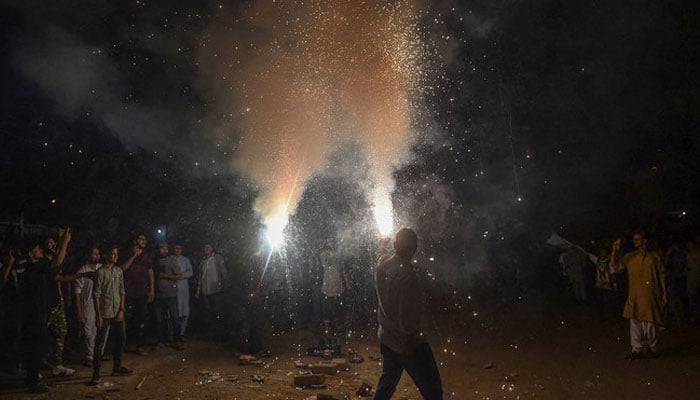 Youths hold lit fireworks during celebrations for Pakistans 75th anniversary of Independence Day in Karachi on August 14, 2022. — AFP