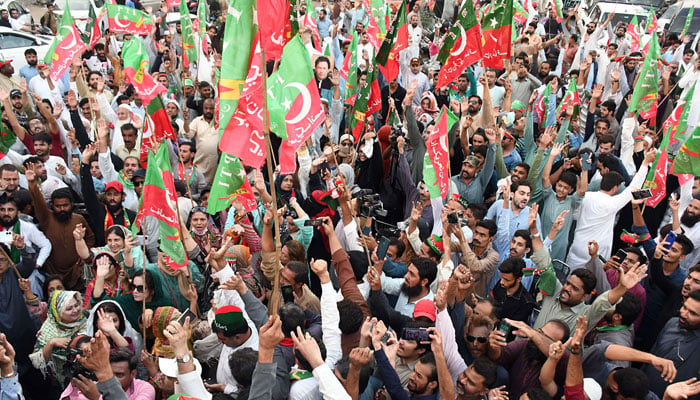 Supporters of PTI hold party flags during a rally in Lahore. — Online/File